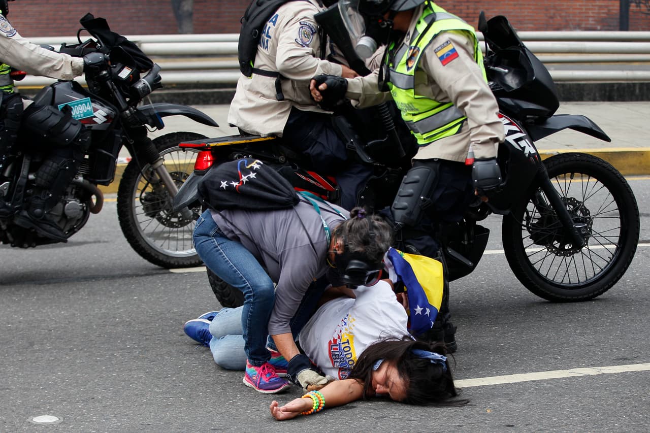 Una manifestante en el suelo recibe ayuda de una compañera. 20 de abril de 2017.