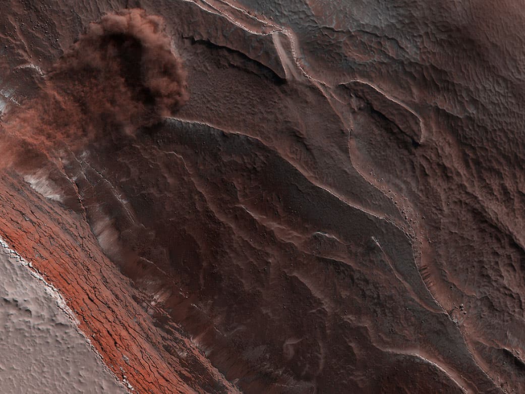 La cámara del orbitador Reconnaissance capturó esta avalancha que se precipitó por un acantilado de 1,640 pies (unos 500 metros) de altura el 29 de mayo de 2019. La imagen también revela las capas en el polo norte de Marte durante la primavera. A medida que las temperaturas aumentan y se vaporiza el hielo también se levanta el polvo.