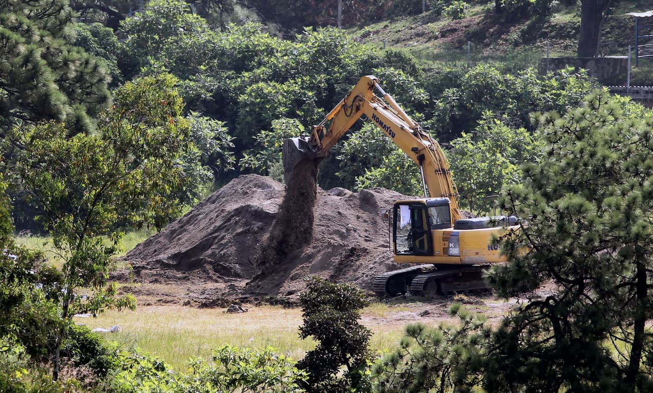 Los expertos comenzaron la exploración del lugar el 3 de septiembre y en total duró ocho días. Es la mayor fosa encontrada en Jalisco, está localizada a media milla de distancia de un cuartel de la Policía Federal y a solo 35 minutos de distancia de la zona suburbana de Guadalajara. No se sabe en qué momento los delincuentes cavaron un pozo de tal profundidad. En la fotografía se ve cómo la maquinaria pesada saca tierra de la fosa común el 10 de septiembre. Ahora lugar está sin vigilancia y el pozo fue tapado con la misma tierra previamente removida.