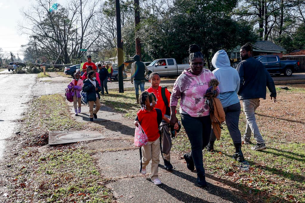 También en Griffin una escuela secundaria resultó dañada y los estudiantes fueron retenidos en cuatro escuelas intermedias para que los padres los recogieran después de que las autoridades determinaran que no era seguro operar los autobuses. La ciudad de Griffin impuso un toque de queda desde las 10:00 pm del jueves hasta las 6:00 am de este viernes. Al menos seis condados de Georgia suspendieron las clases este viernes. En la imagen, niños regresan a casa de la escuela tras el tornado en Selma, Alabama.