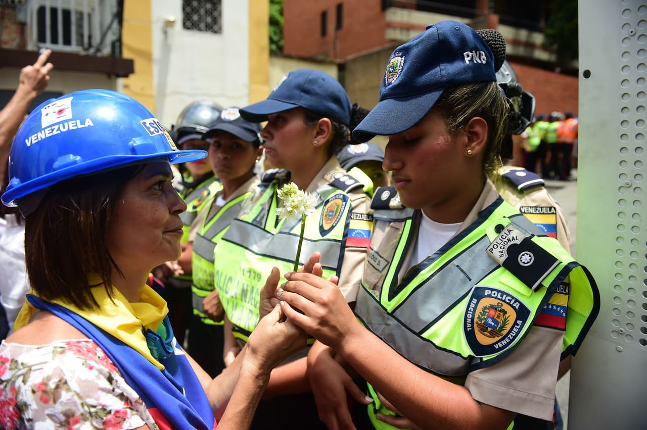 Una manifestante se acerca a una integrante de la Policía Nacional Bolivariana.