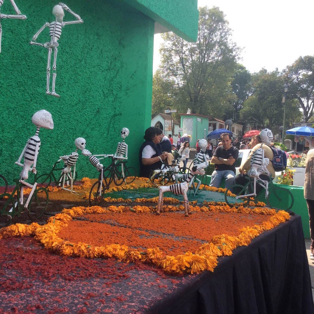 Esqueletos y pétalos de cempasúchil, la flor tradicional del Día de Muertos, en la entrada del camposanto