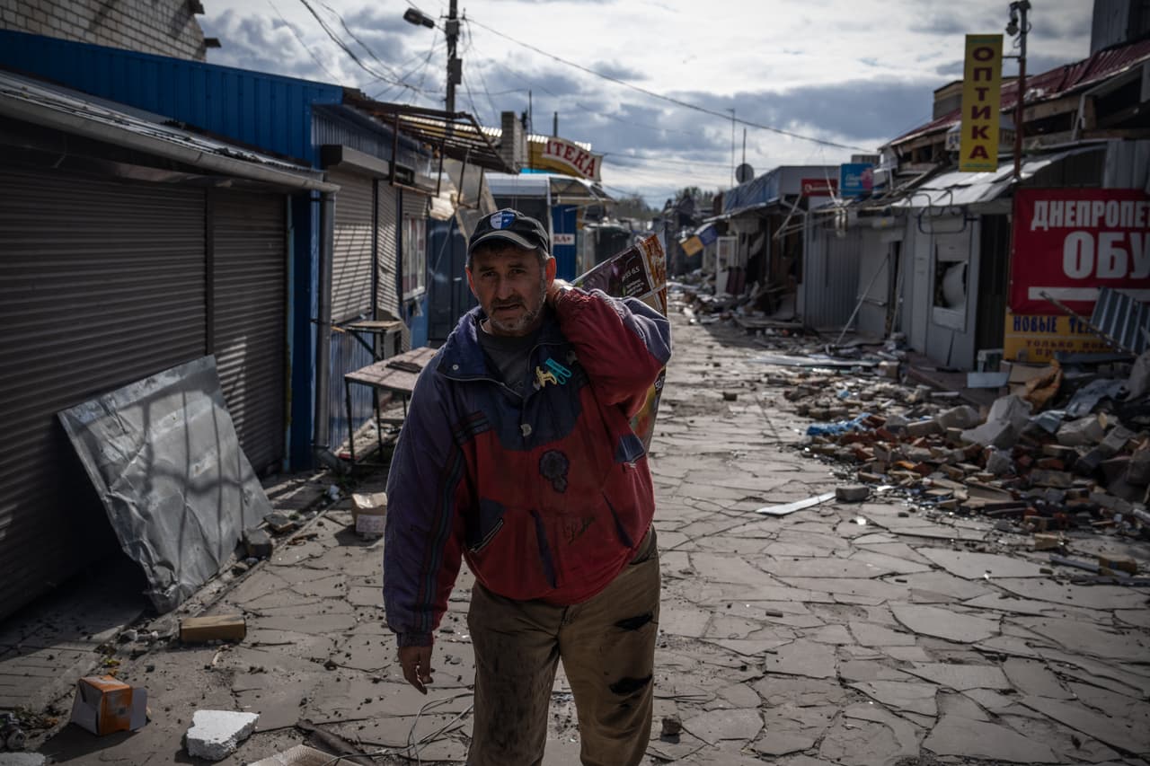 Un hombre recupera productos de su tienda en un mercado que ha sido parcialmente destruido por los combates entre las fuerzas de ocupación ucranianas y rusas. La región de la capital de Ucrania fue atacada por drones kamikaze de fabricación iraní en la madrugada del jueves.