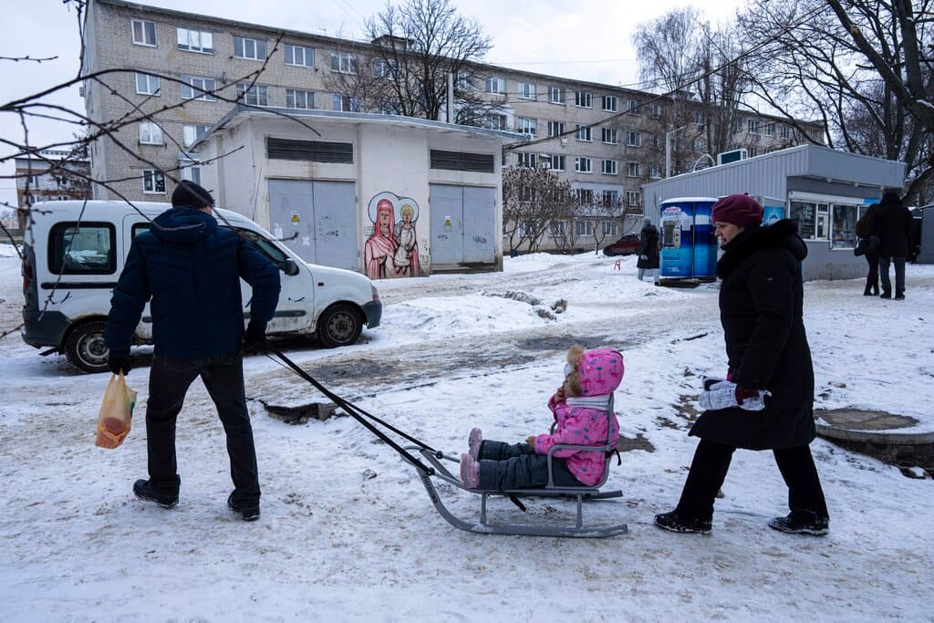 Un hombre empuja el trineo donde lleva a su hija por una calle de Kharkiv. El presidente ucraniano, Volodymyr Zelensky, dijo recientemente que cualquier escalada podría depender de lo que ocurra en este ciudad, también base de Yevheniy Murayev, identificado por la inteligencia británica como la persona que Rusia estaba considerando instalar como presidente. "Kharkiv tiene más de un millón de ciudadanos", dijo Zelensyy en una entrevista a 
<i>The Washington Post</i>. "No va a ser solo una ocupación; va a ser el comienzo de una guerra a gran escala".