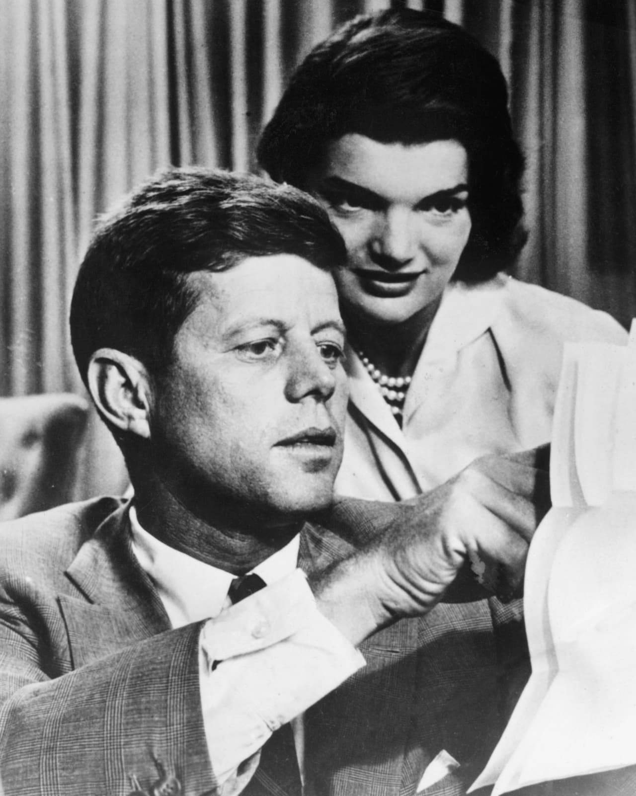 John F. Kennedy (1917–1963) era un gran fan de James Bond. En una cena en 1960 conoció al autor de la saga, Ian Fleming, y 
<a href="http://www.huffingtonpost.com/2014/02/17/presidents-day-44-facts_n_4802776.html">se dice que especularon sobre cómo se podría derrocar a Fidel Castro</a>. De Kennedy, presidente entre 1961 y 1963, se ha dicho todo: condujo una lancha torpedera en el Pacífico Sur durante la segunda guerra mundial, fue el primer presidente católico y el primero en haber nacido en el siglo XX. Su asesinato, a manos de 
<a href="https://es.wikipedia.org/wiki/Lee_Harvey_Oswald">Lee Harvey Oswald,</a> ha sido motivo de millones de teorías conspirativas. Su gran frase fue: "No preguntes qué es lo que tu país puede hacer por ti; pregunta qué es lo que tú puedes hacer por tu país". En su mandato trabajó por la reducción de impuestos, atención a la tercera edad y la población afroamericana, el PIB creció 5.5 %, y bajó el desempleo. Esta fotografía fue tomada en la década del 50 al lado de su esposa, Jacqueline Bouvier Kennedy.