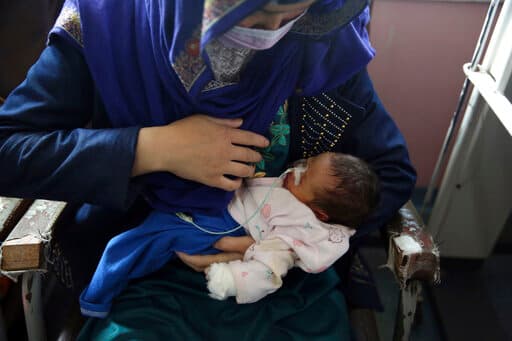<b>Una maternidad quedó bañada en sangre</b> cuando tres hombres armados entraron a tiros y mataron a trabajadores del hospital, madres y bebés recién nacidos en Kabul. En la foto, una madre sostiene a su bebé de dos días en el Hospital de Niños Ataturk, un día después de que fueron rescatados tras el ataque mortal en otro hospital maternal.