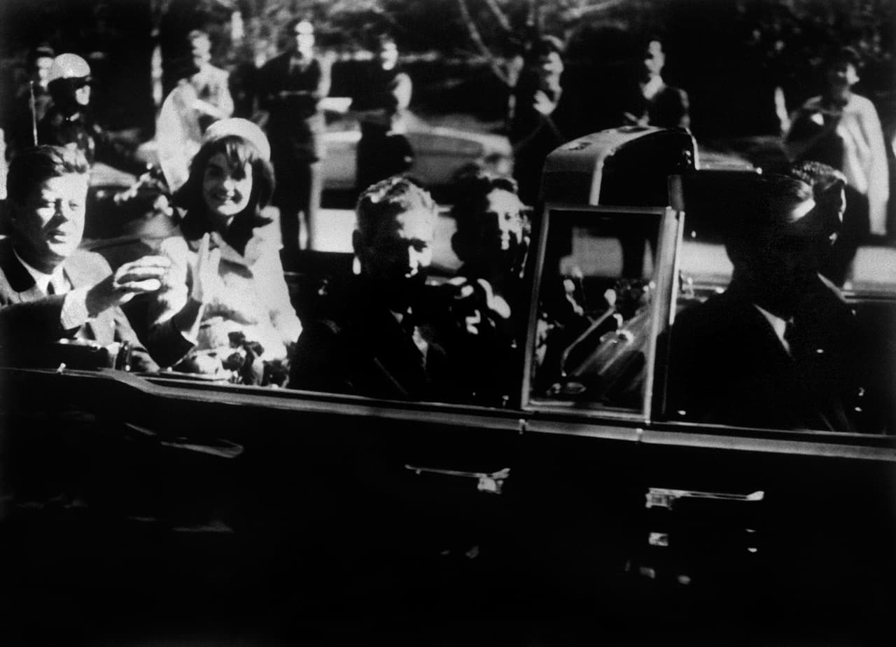 La gestión de JFK fue interrumpida abruptamente el 22 de noviembre de 1963. Durante un recorrido en un carro descapotado en Dallas, JFK fue asesinado por tres disparos de un francotirador. Lee Harvey Oswald, un ex marine que había vivido en Rusia, fue el primer y único sospechoso del asesinato. La fotografía fue tomada unos minutos antes de la tragedia.
<br>