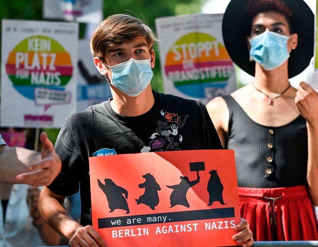 "Somos muchos. Berlín contra los Nazis", se lee en la pancarta que sostiene este joven, que también lleva mascarilla.