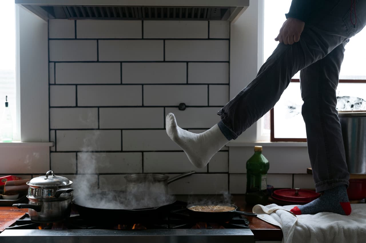 Jorge Sanhueza-Lyon, residente de Austin, Texas, se para en la encimera de su cocina para calentarse los pies sobre su estufa de gas. Según Toby Baker, quien encabeza la Comisión de Calidad Ambiental de Texas, unas 264,000 personas se vieron afectadas por sistemas de agua no operativos.