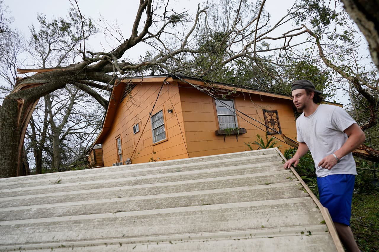 Un hombre recoge escombros de su residencia en Lake Charles.