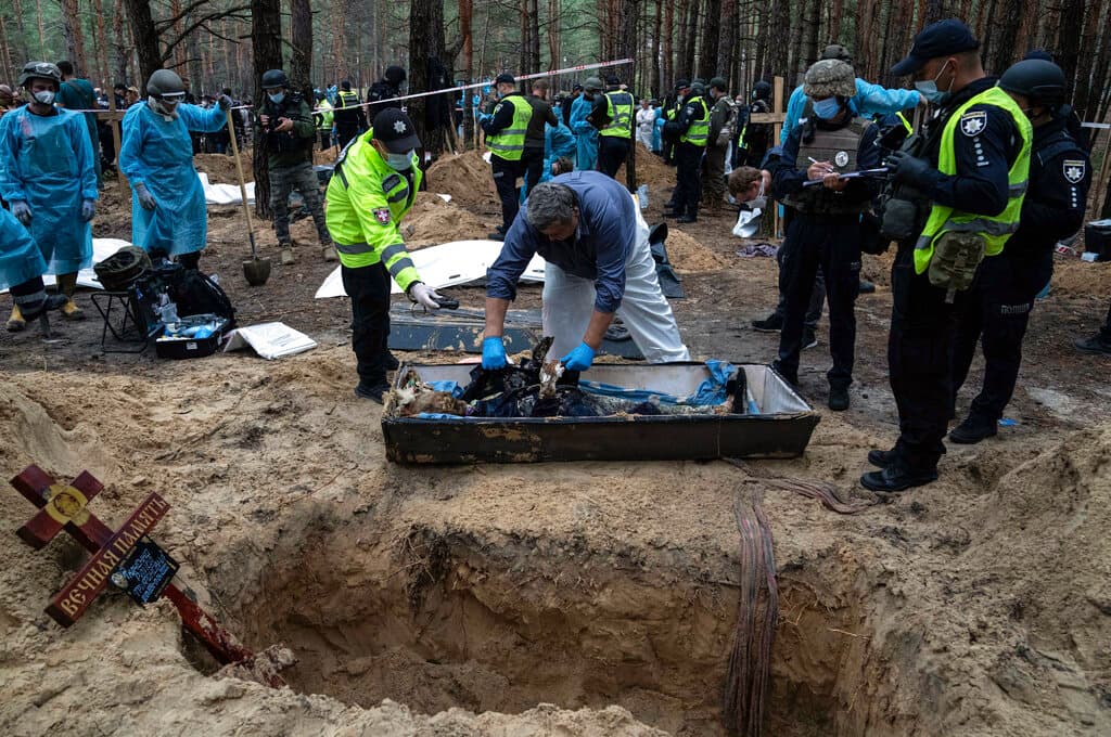 En esta imagen, los trabajadores examinan un cuerpo durante una exhumación.