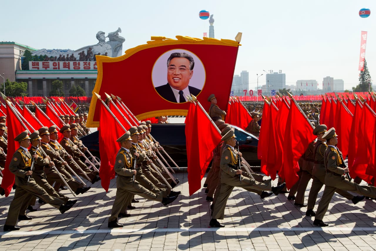 En la fotografía, los soldados marchan frente a una imagen del antiguo líder norcoreano Kim Il Sung.
