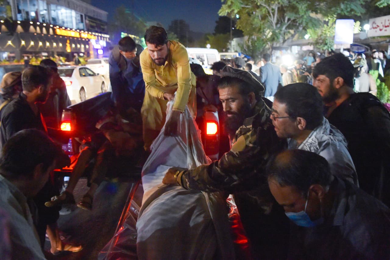 Un grupo de personas carga varios cuerpos a un camión después de las explosiones en Kabul. Según la cadena CNN, citando a funcionarios de Seguridad Nacional, 
<a href="https://twitter.com/kaitlancollins/status/1430894131077779472">parece ser un ataque suicida.</a>