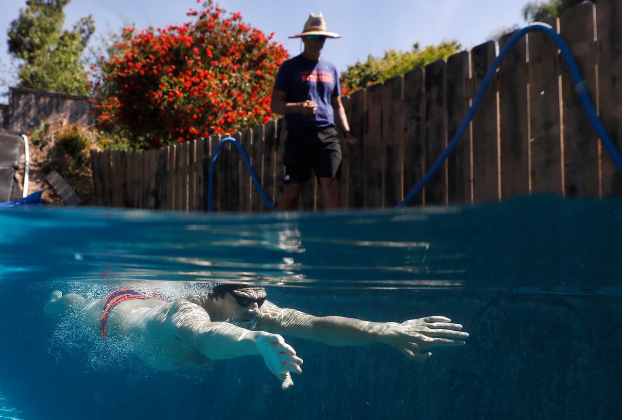 El nadador olímpico Michael Andrew durante un entrenamiento en una piscina residencial junto a su padre, el 6 de mayo. Aunque los Juegos Olímpicos fueron pospuestos para el próximo año por la pandemia, atletas profesionales y amateurs de alta competencia se mantienen en forma a pesar del aislamiento. 
<a href="https://www.univision.com/noticias/salud/mapa-actualizado-del-coronavirus-cifras-de-casos-confirmados-y-fallecidos"><u>Vea aquí nuestro mapa actualizado del coronavirus: cifras de casos confirmados y fallecidos</u></a>
<br>