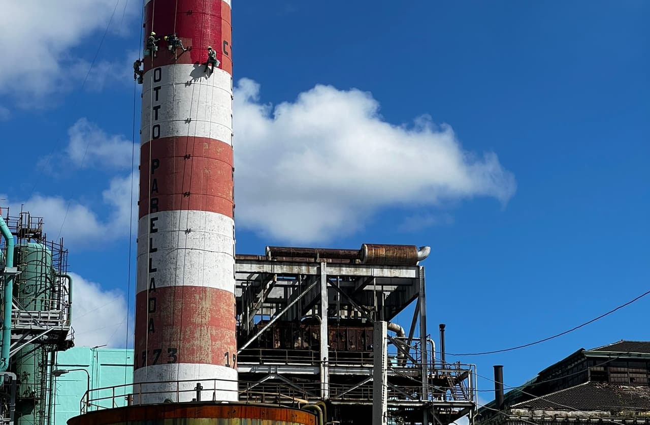 Workers scale one of the smokestacks at the The Otto Parellada Power Plant in Habana.