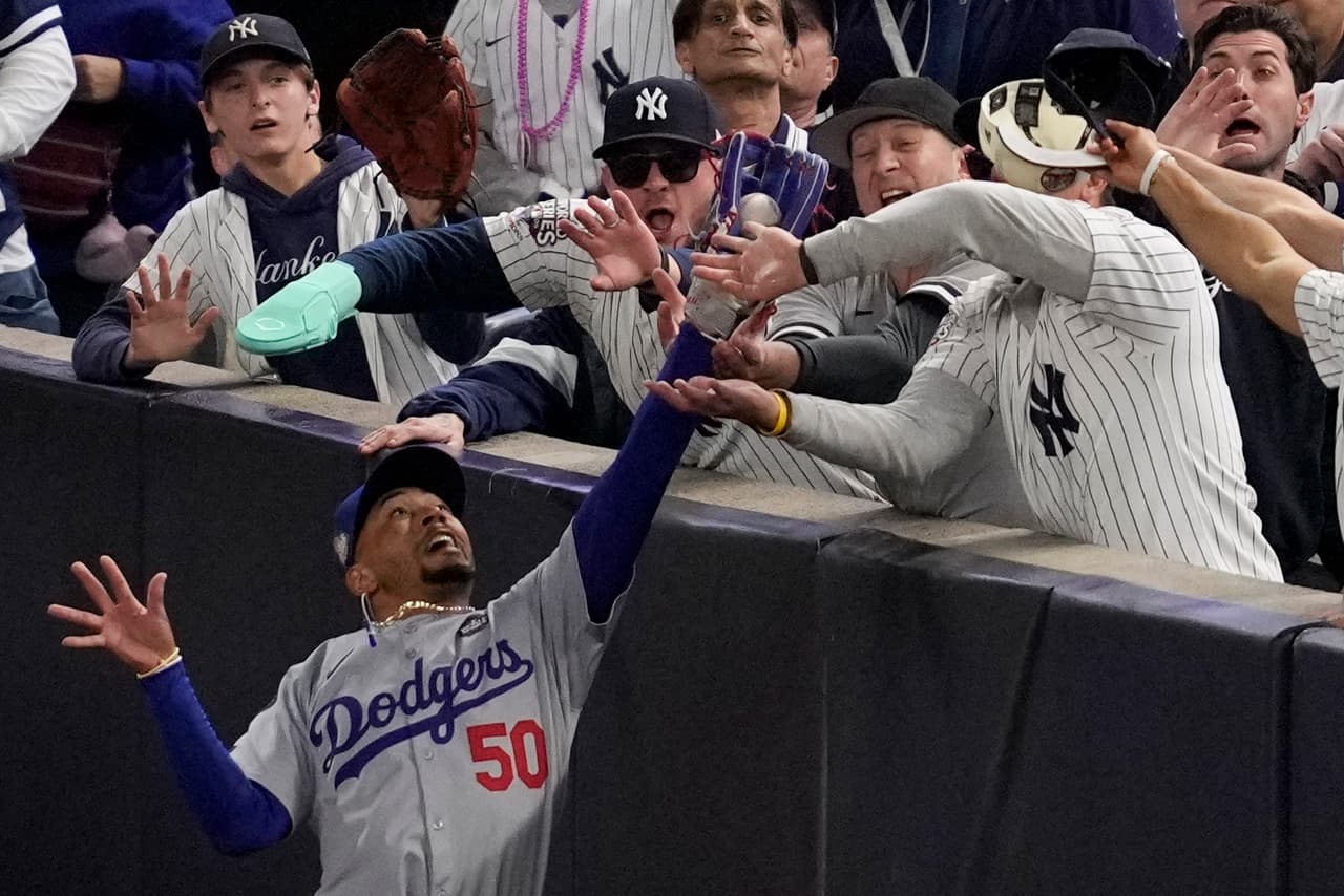 Aficionados interfieren con una pelota atrapada por el jardinero derecho de los Dodgers de Los Ángeles, Mookie Betts, durante la primera entrada del cuarto juego de la Serie Mundial de béisbol contra los Yankees de Nueva York, el martes 29 de octubre de 2024, en Nueva York. 
<a href="https://www.youtube.com/watch?v=y1VboBz_MrI" target="_blank">Los Dodgers ganaron la octava Serie Mundial de su historia frente a sus rivales neoyorquinos. </a>