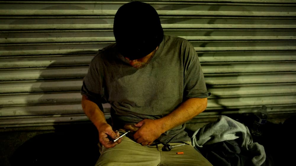 En medio de una acera de Skid Row, D. J. Meek, de 40 años, se inyecta una dosis de heroína luego de haber fumado 'crystal meth'.