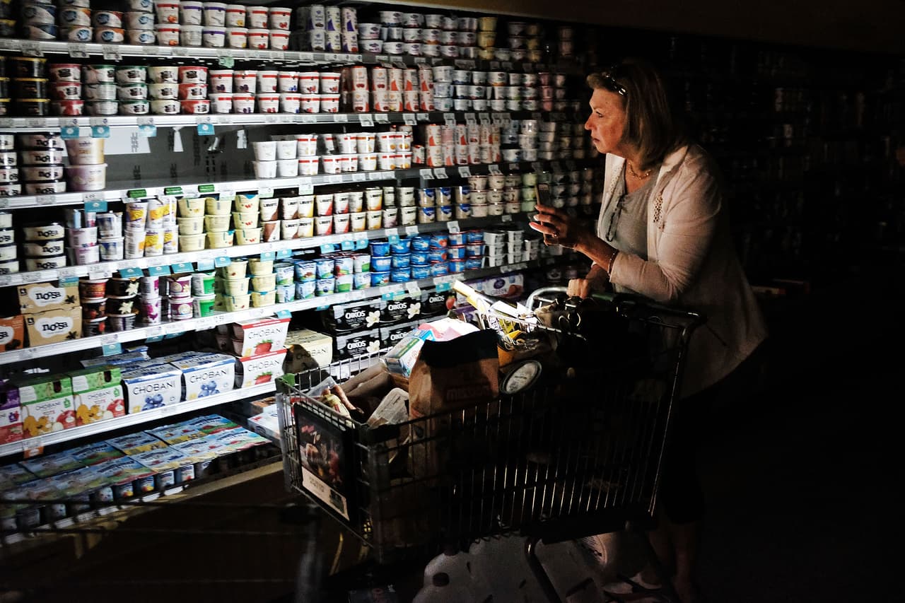 Aún tres días después del huracán, este miércoles los cortes de energía continuaban afectando a 3.5 millones de usuarios. En la imagen, una mujer comprando en uno de los pocos supermercados abiertos, con electricidad limitada este 13 de septiembre en Naples.