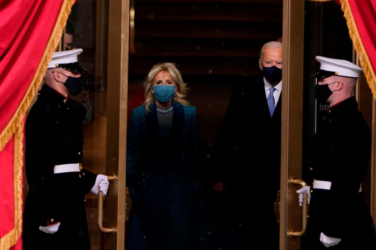 <b>La excepcional juramentación en medio de la pandemia</b>
<br>
<br>Con muy poco publico y otras condiciones excepcionales por el covid-19, 
<a href="https://www.univision.com/temas/joe-biden"><u>Joe Biden</u></a> fue juramentado el 20 de enero de 2021 como el presidente número 46 de Estados Unidos.
<br>
<br>El evento se realizó a solo días del 
<a href="https://www.univision.com/noticias/politica/en-fotos-partidarios-de-trump-entran-a-la-fuerza-al-capitolio-de-estados-unidos-protesta-donald-trump-joe-biden-elecciones-2021-fotos"><u>histórico asalto al Congreso</u></a>, donde un grupo de partidarios de Donald Trump intentó detener la confirmación de la victoria del demócrata. El expresidente no estuvo en el tradicional acto de traspaso del poder, un augurio de que las relaciones entre los partidos sería complicada. 
<br>
<br>La fotografía muestra a Biden y su esposa Jill saliendo al lugar donde sería juramentado como presidente frente al Capitolio el 20 de enero de 2021.
<br>