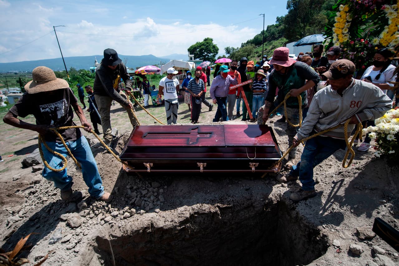Sepultureros mueven un ataúd durante un funeral en el cementerio de San Miguel Xico, en medio de la pandemia de coronavirus.
<br>
<br>En una entrevista con la agencia AFP, José Pérez, panadero de 40 años, cuenta que pasó de la incredulidad a la tragedia cuando murieron sus dos hermanas por el coronavirus. En un mismo terreno están las casas de cinco hermanos. En mayo, todos enfermaron. Adriana, de 43 años, y Guadalupe, de 48, fallecieron.
<br>
<br> 
<br>
