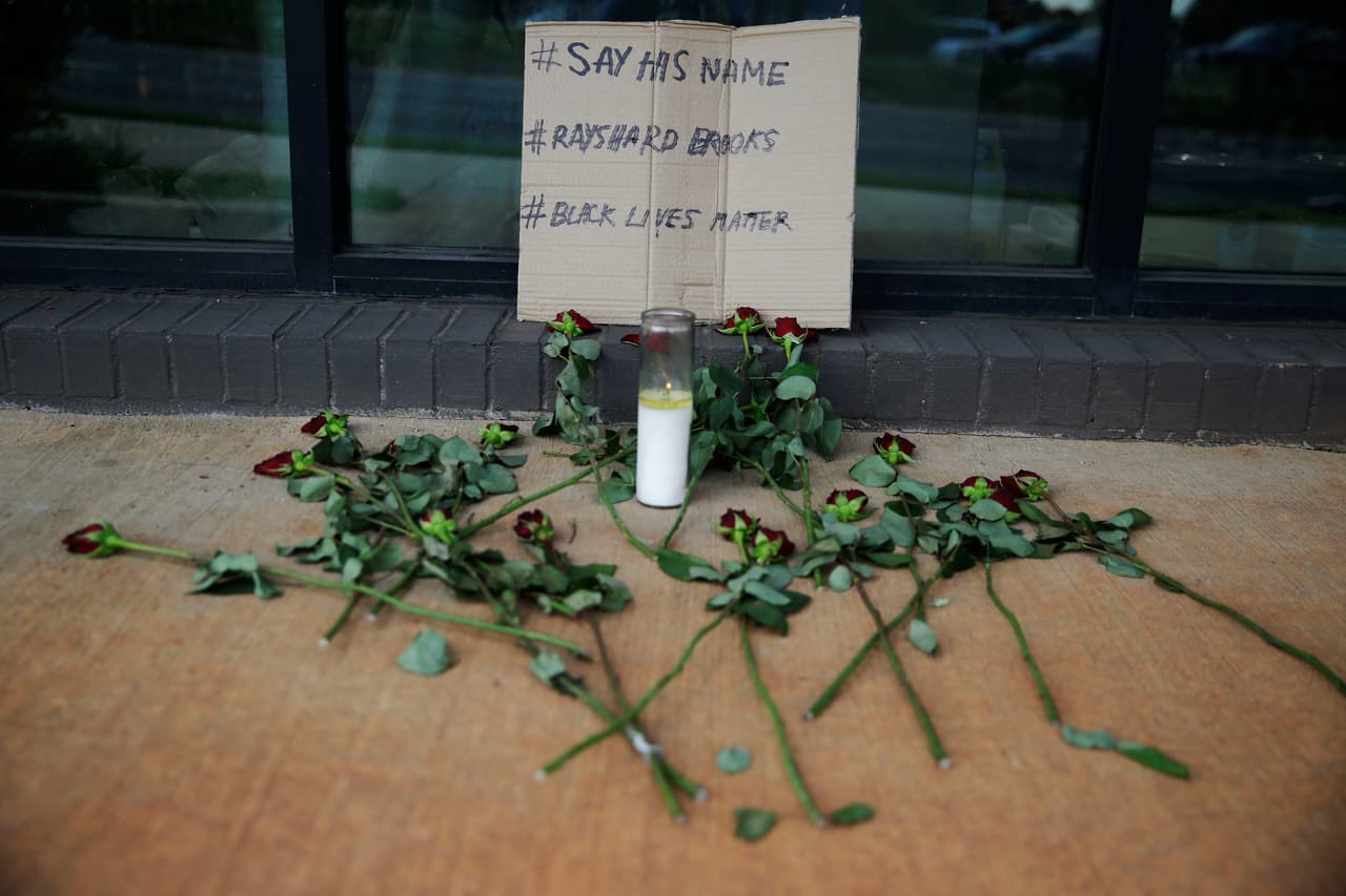 Mientras aún el país está dolido por la muerte de George Floyd a manos de la Policía de Minneapolis, Rayshard Brooks, otro afroestadounidense, recibió un disparo mortal de la policía el viernes por la noche después de un forcejeo tras una prueba de sobriedad en Atlanta. 
<b>Las autoridades dijeron que el hombre había agarrado la pistola Taser de un oficial, pero estaba huyendo cuando le dispararon. </b>En la foto, este sábado 13 de junio, en Atlanta, se veía este pequeño altar con rosas y un letrero, cerca del restaurante Wendy's donde Brooks murió.