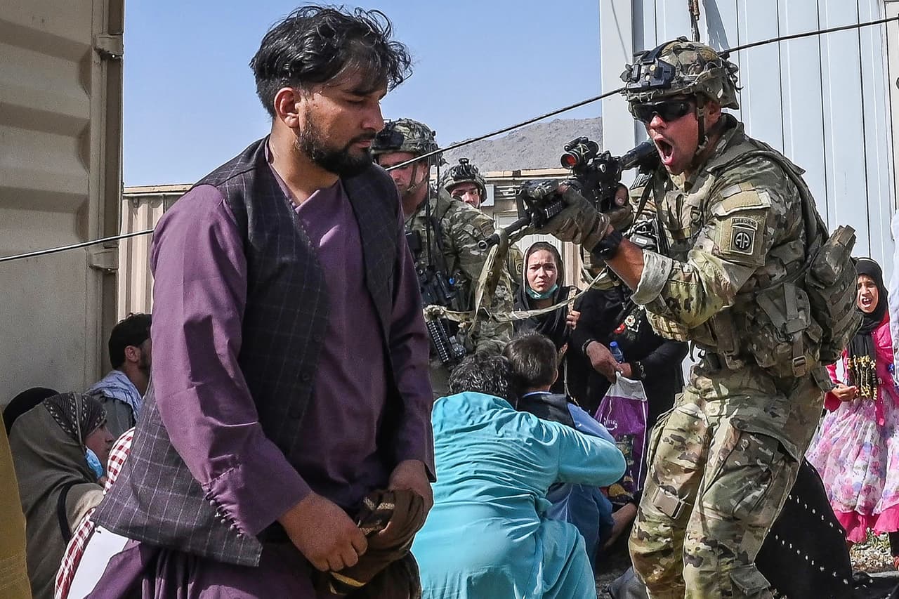 Un soldado estadounidense apunta con su arma a una de las personas desesperadas en el aeropuerto de Kabul. Washington ha enviado a 6,000 militares para evacuar a unos 30,000 diplomáticos estadounidenses y a ciudadanos afganos que cooperaron con Estados Unidos y que temen represalias de los talibanes.
<br>