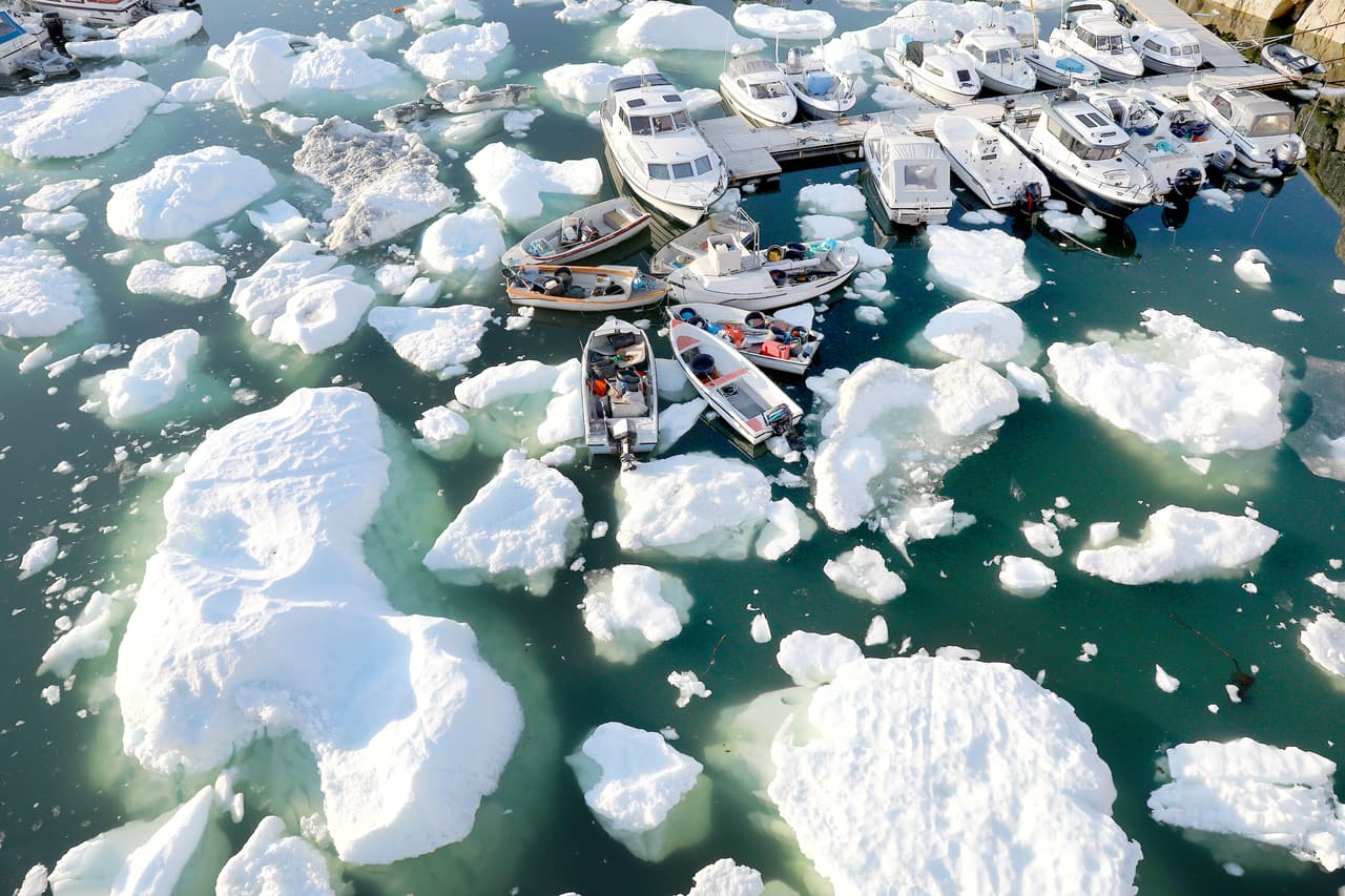 Bloques de hielo flotan junto a los barcos del puerto de Ilulissat, Groenlandia, el 2 de septiembre de 2021. La capa de hielo que cubre a la isla más grande del mundo se está derritiendo muy rápido, está elevando el nivel del mar y ha aumentado el riesgo global de inundaciones. 
<br>
<br>Una investigación publicada por la revista 
<a href="https://www.nature.com/articles/s41467-021-26229-4"><u>Nature Communications</u></a> el 1 de noviembre encontró que de la superficie helada de Groenlandia se derritió en términos que se elevan a 3.5 billones de toneladas (
<i>trillions</i> en inglés) de hielo entre 2011 y 2020.