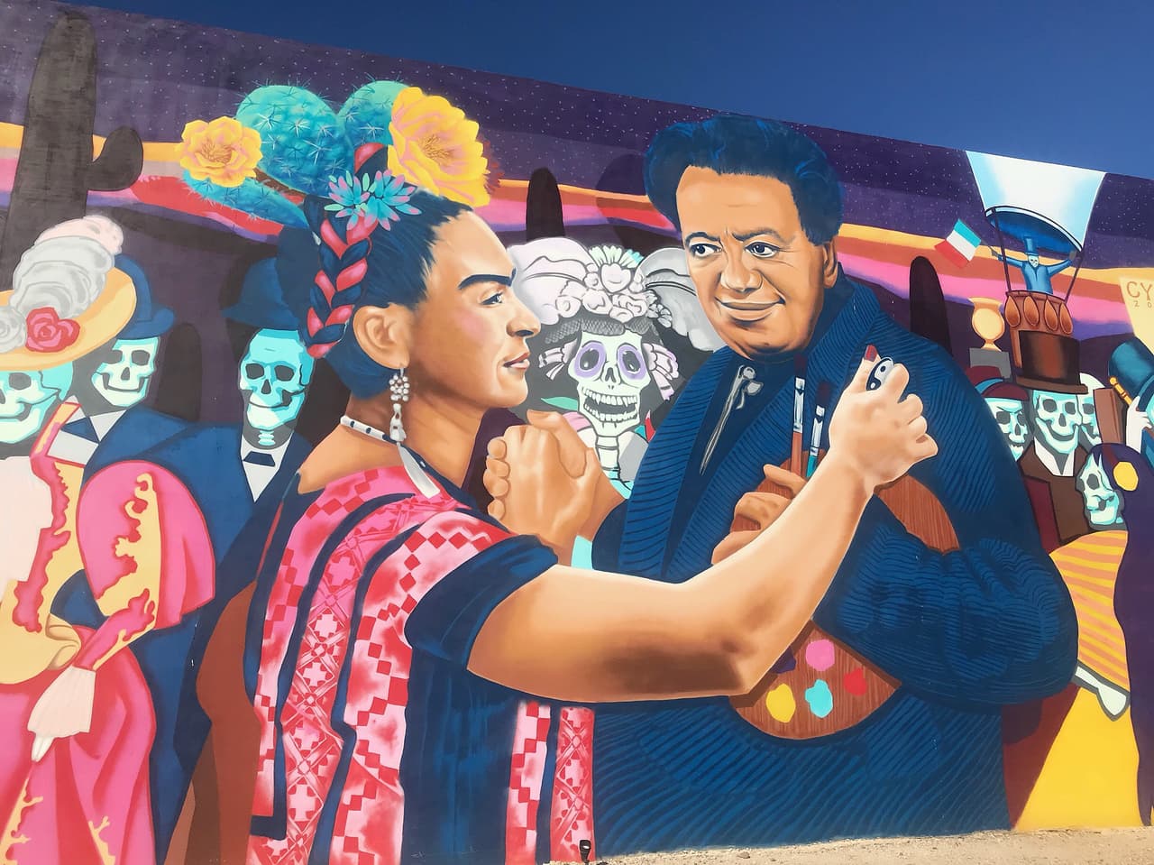 El mural “
<i>Dia de lo Muertos</i>” se encuentra en el 
<a href="https://goo.gl/maps/CQMY8TPnNVnjLADL9" target="_blank">895 Calle de los Higos.</a>
<br>
<br>Artista: Rock “CyFi” Martínez
