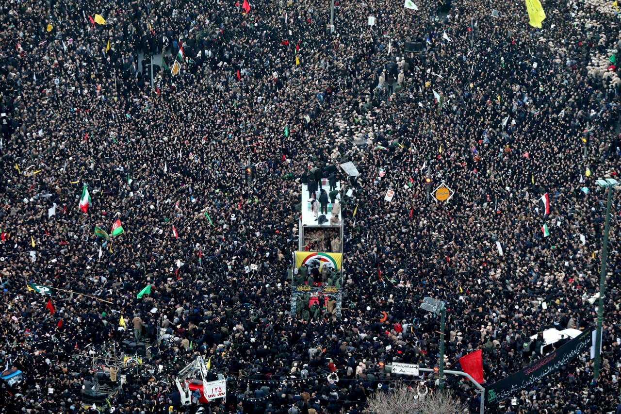 Los ataúdes con los cuerpos del general Qassem Soleimani y de otros cuatro iraníes muertos en un ataque aéreo en Irak son transportados en un camión que se abre paso entre la multitud congregada en la ciudad de Mashhad para rendirle homenaje.