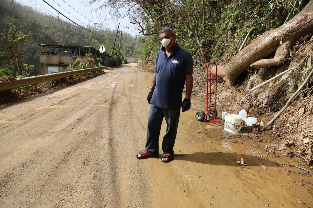 Orlando Osorio, residente de Rio Abajo, Utuado, recoge agua de un manantial.