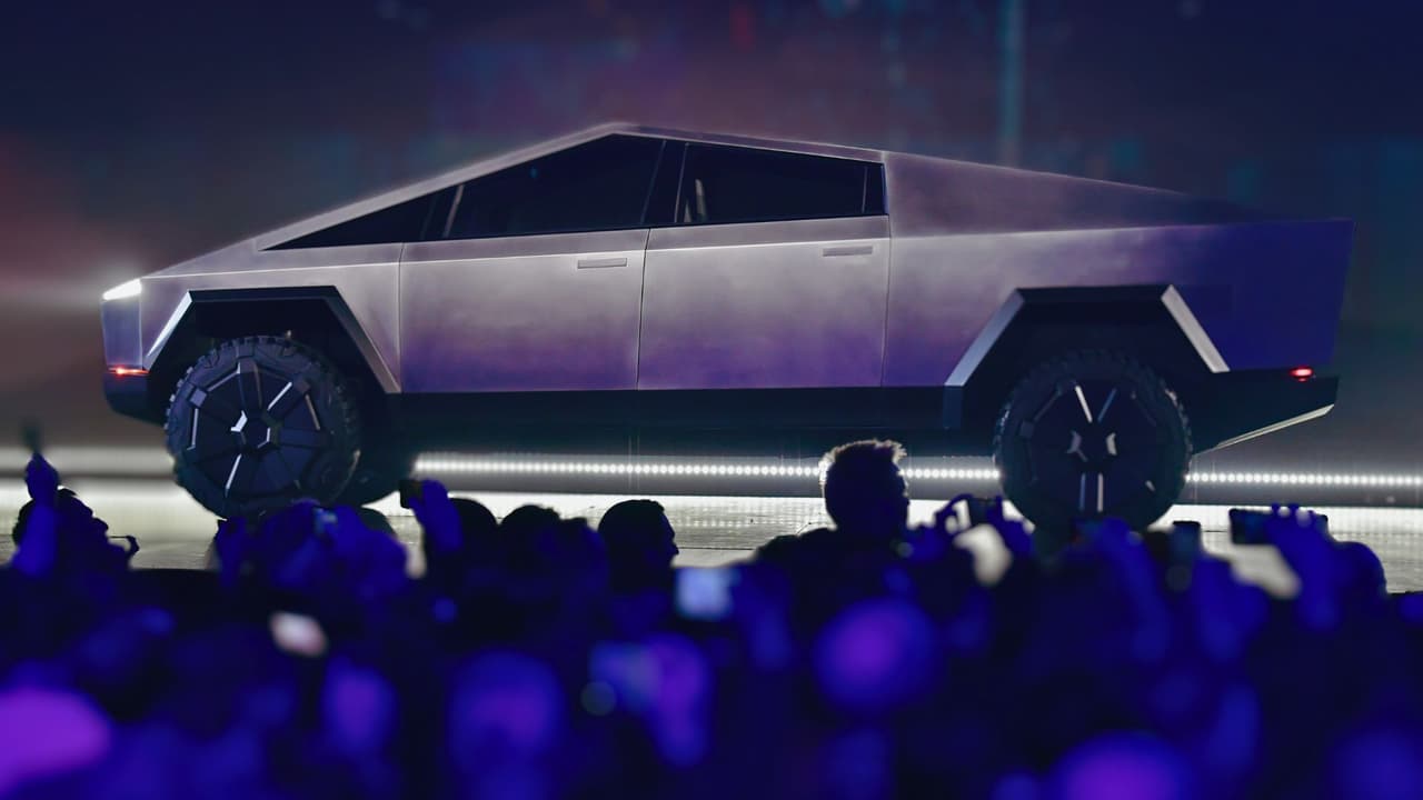 Personas toman fotos en la presentación de la Cybertruck de Tesla, un vehículo totalmente eléctrico alimentado por batería, en el Centro de Diseño de Tesla en Hawthorne, California, el 21 de noviembre de 2019.