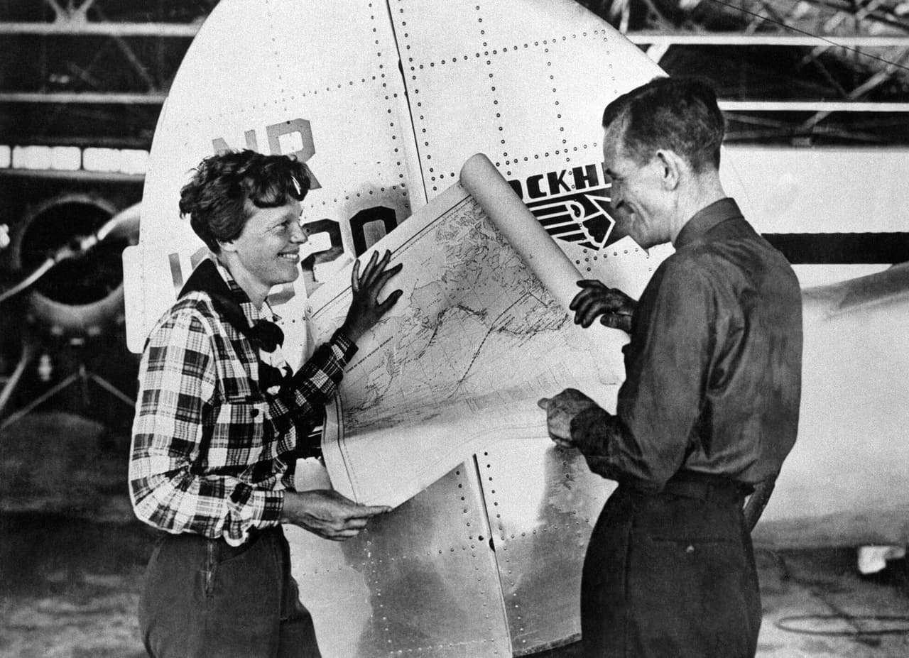 Amelia Earhart y Fred Noonan con el mapa de su última ruta en el Pacífico, en mayo de 1937. Llegaron a Nueva Guinea luego de 21 días de viaje. Según detalla el Museo Earhart, ella llegó cansada y enferma allí para comenzar la siguiente etapa del viaje. 
<br>
