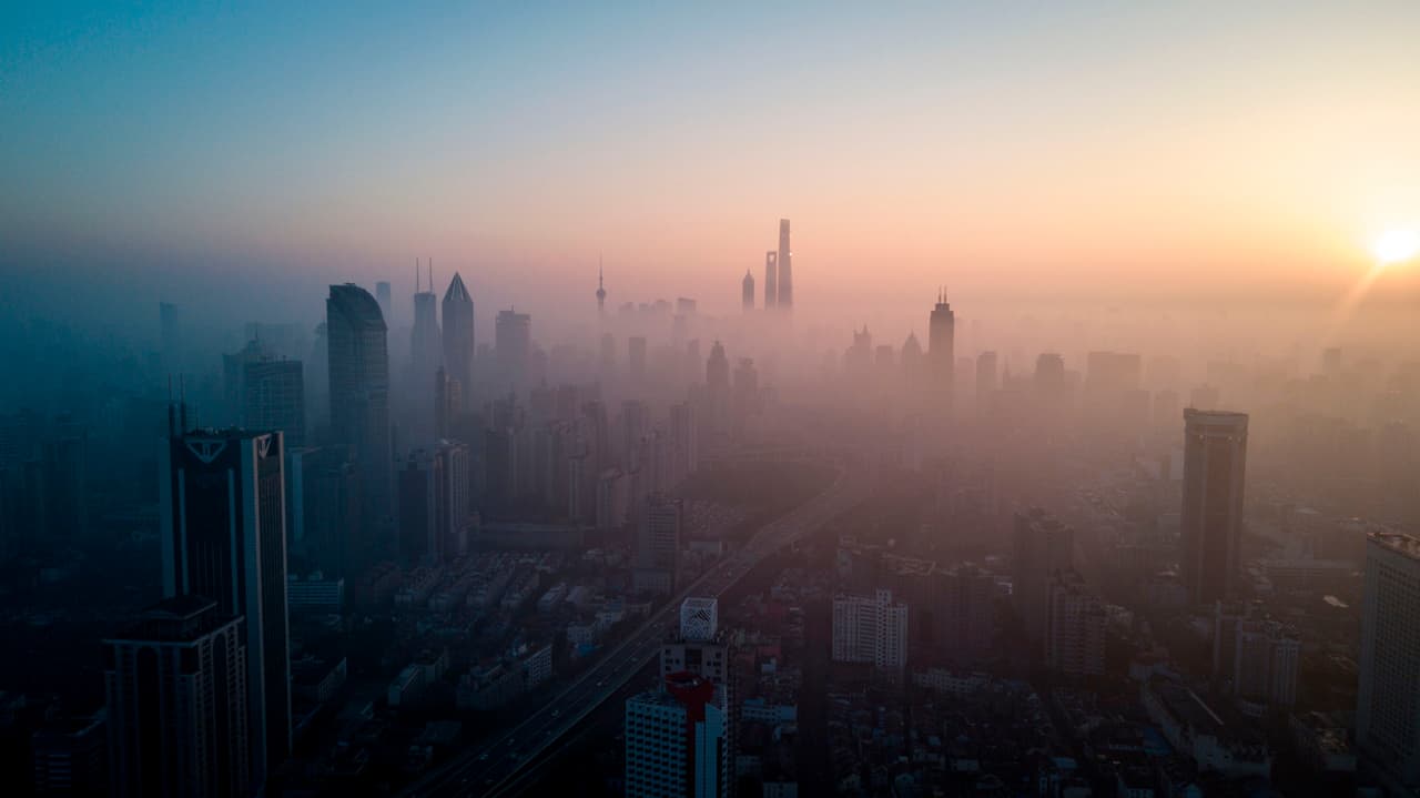 El sol cae en el horizonte de Shanghai detrás de los edificios cubiertos de smog en febrero de 2018. 
<a href="https://www.univision.com/noticias/contaminacion/en-fotos-la-nube-toxica-que-viaja-sobre-china-fotos">China libra una guerra contra la polución</a>, el mayor problema que ha traído el desarrollo industrial de las cuatro últimas décadas.