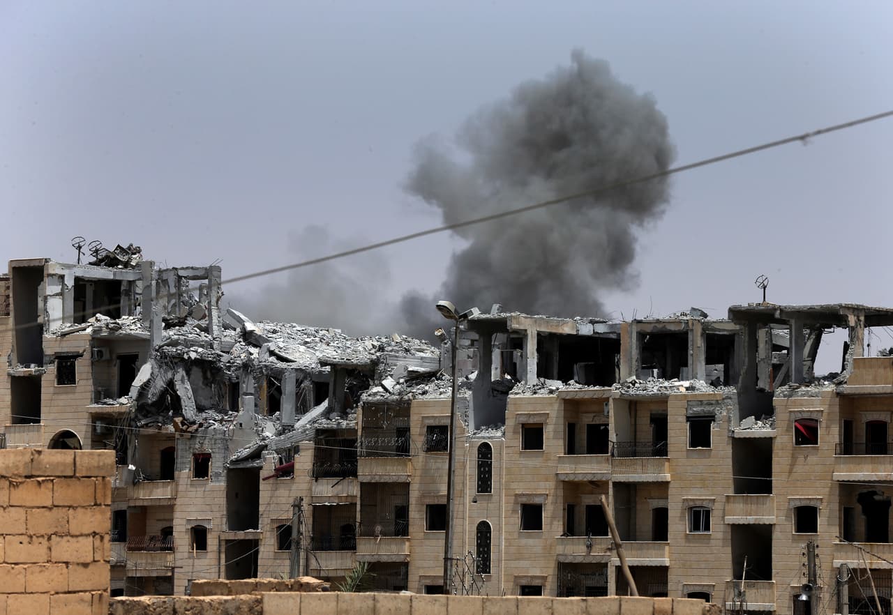 Esta fotografía tomada en julio de 2017 muestra el humo que se levanta sobre los edificios recién destrozados en Raqqa. La ciudad recibió los constantes bombardeos de la coalición entre las Fuerzas Democráticas Sirias y EEUU.