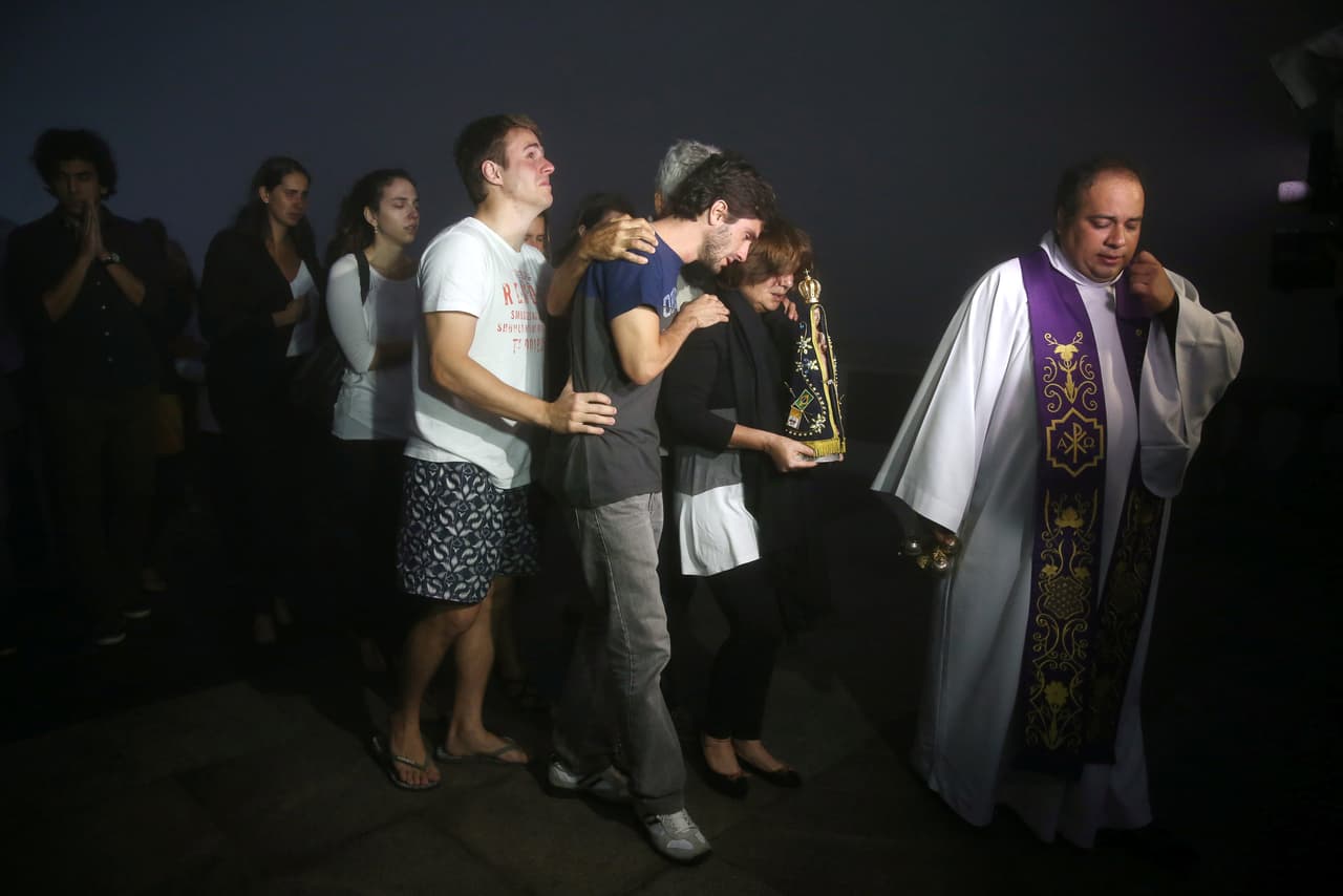 Veinte periodistas, de los 21 que acompañaban al Chapecoense en su trayecto hasta Medellín para enfrentarse al Atlético Nacional de Colombia, murieron en el siniestro registrado en la noche de este lunes. En la foto, familiares de uno de ellos, Guilherme Marques, lloran durante una misa realizada en Río de Janeiro. (Foto de Pilar Olivares/Reuters)