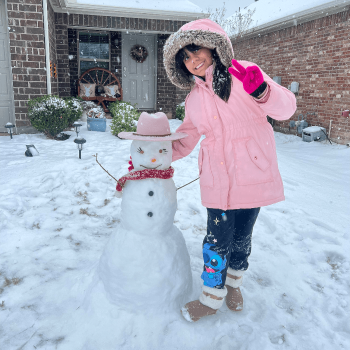Verónica tomó esta fotografía de su hija con su mono de nieve que porta un sombrero rosa y una bufanda roja en Corith, Texas.