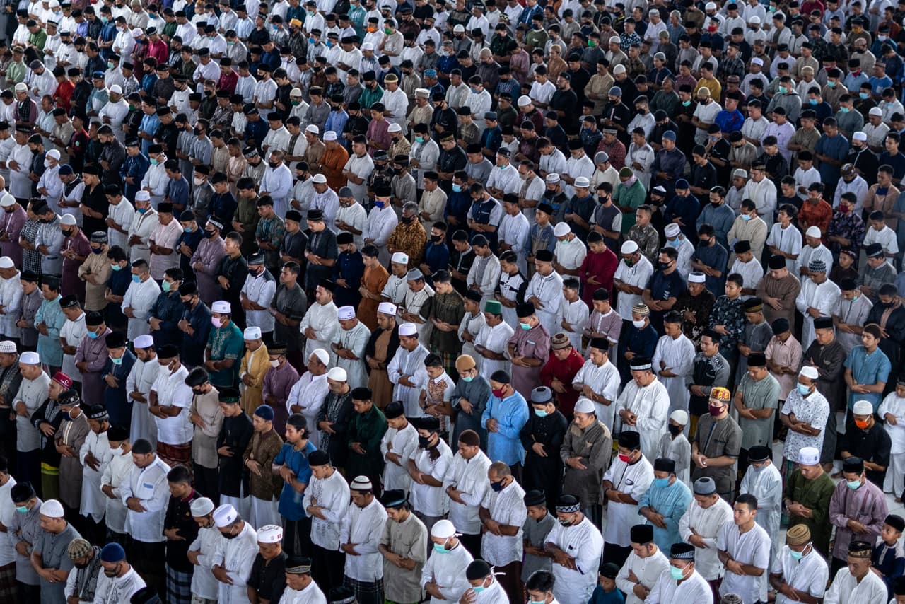 Cientos de hombres musulmanes oran en una mezquita en Aceh, Indonesia, el domingo 24 de mayo. Luego de varias semanas de confinamiento, en esta nación musulmana millones se han reunido para celebrar el final del mes de ayuno del Ramadán.
