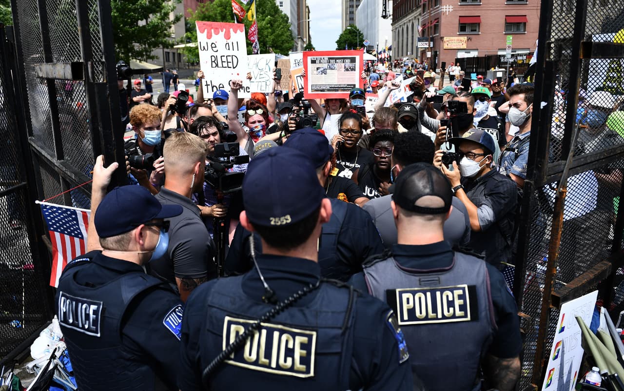 Un grupo de manifestantes del grupo 
<i>Black Lives Matter </i>es impedido de pasar los portones de la seguridad del BOK Center.