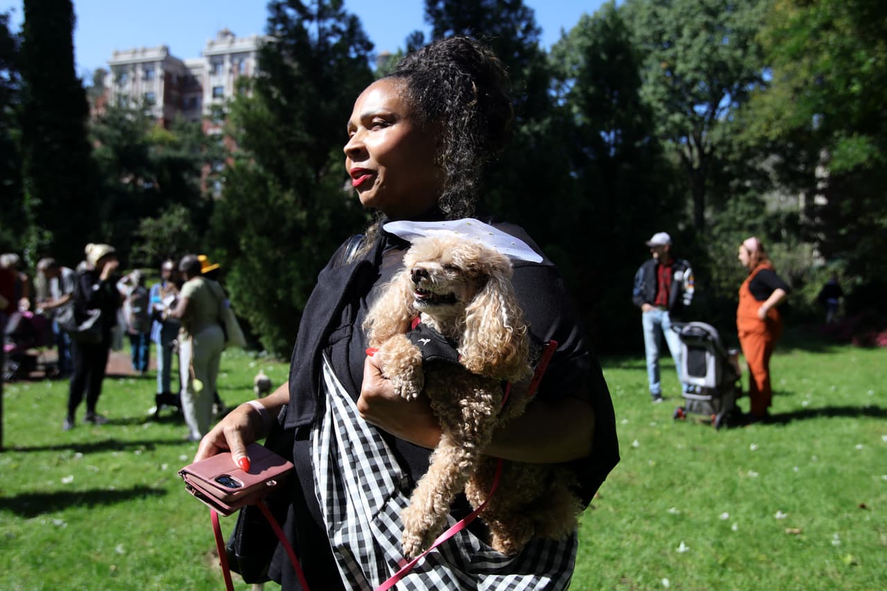 Una mujer espera con su adorable mascota para recibir la bendición de San Francisco de Asís.