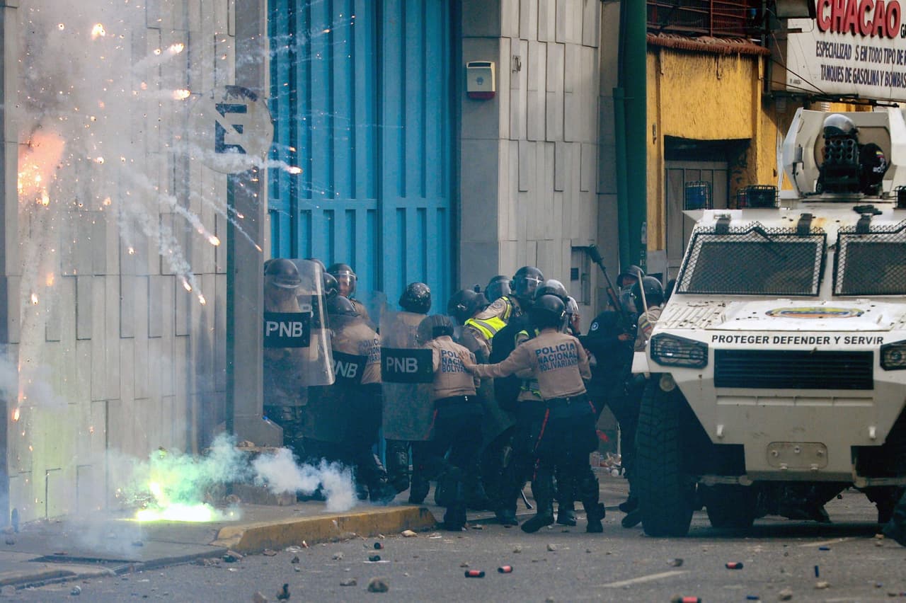 Un grupo de policías recibe un ataque con fuegos artificiales (pirotécnicos) de los manifestantes.