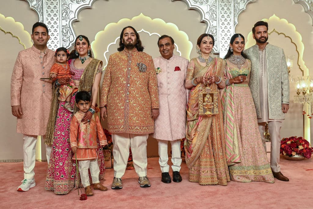 El magnate multimillonario y presidente de Reliance Industries Mukesh Ambani (centro) con su esposa Nita Ambani (tercera desde la derecha), su hija Isha Ambani (segunda desde la derecha), sus hijos Akash Ambani (a su izquierda) y Anant Ambani (C, izquierda), su nuera Shloka Mehta (2L) y su yerno Anand Piramal posan para fotos cuando llegan para asistir a la ceremonia de boda de Anant y Radhika Merchant en Mumbai el 12 de julio de 2024.