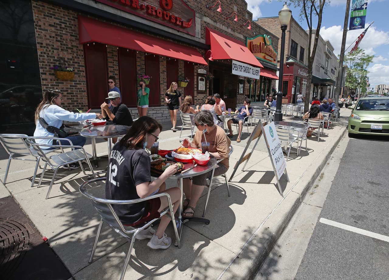 <b>Illinois.</b> Clientes en el área exterior de un restaurante en la ciudad de Lagrange el 29 de mayo, antes de que permitieran de nuevo el uso de los espacios interiores de estos locales el 26 de junio. 
<br>
<br>Luego de un aumento considerable en los casos, el 20 de julio la alcaldesa de Chicago anunció que los bares sin comida se limitarían a servir en exteriores y ordenó un límite máximo en las mesas. El gobernador de Illinois, J.B. Pritzker, advirtió que no dudará en cerrar restaurantes y bares en todo el estado nuevamente si la tendencia al alza del covid-19 continúa.