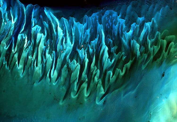 <b>Arena del Océano, Bahamas. GANADORA. "</b>Aunque la imagen puede parecerse a una pintura... es de hecho una imagen satelital de las arenas y algas marinas en las Bahamas", señala la NASA de esta foto. Esta foto tomada en enero de 2001 fue votada como la mejor. Ganó el 66% de la votación final, superando a la otra espectacular fotografía del volcán Raikoke.
<br>