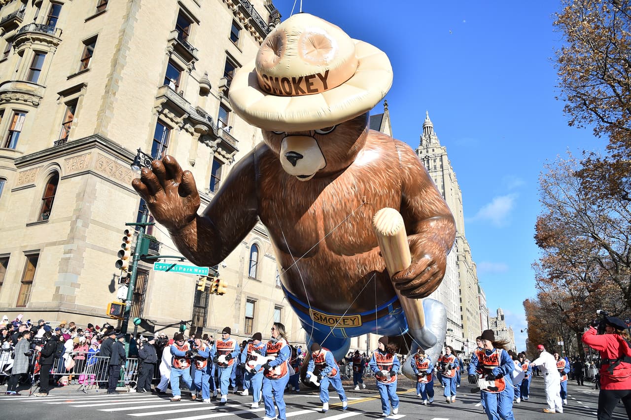 El oso Smokey saluda a las decenas de personas apostadas a los costados de la avenida. Se espera que asistan al desfile alrededor de 3.5 millones de personas.