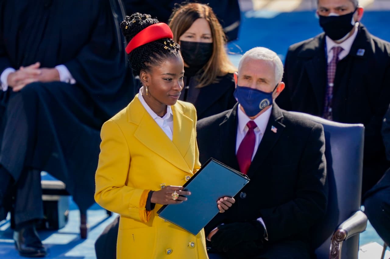 Amanda Gorman, encargada de recitar un poema en honor al nuevo presidente. Al fondo el exvicepresidente Mike Pence.