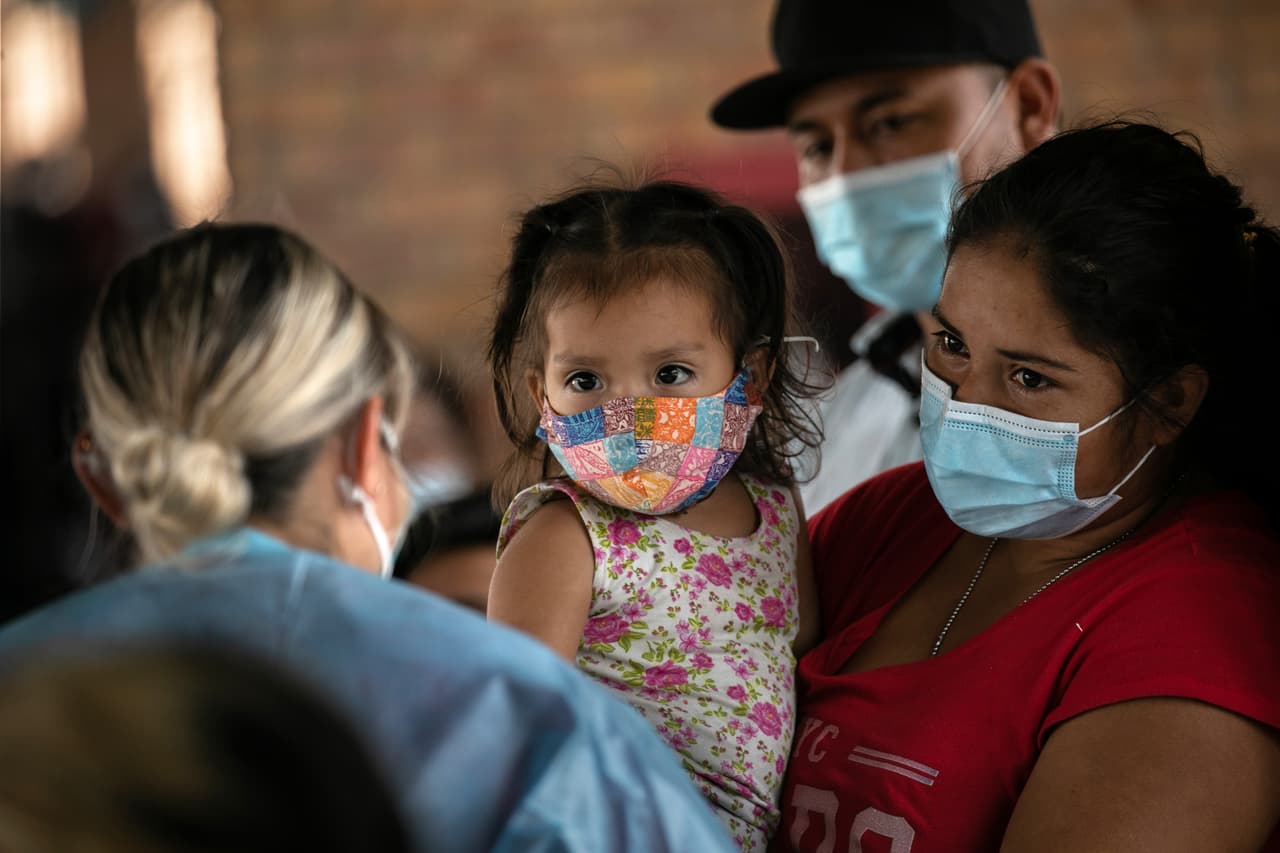 <b>Los ojos más lindos. </b>Esta madre inmigrante sostiene a su hija mientras espera los resultados de la prueba Covid-19 el 25 de febrero de 2021.