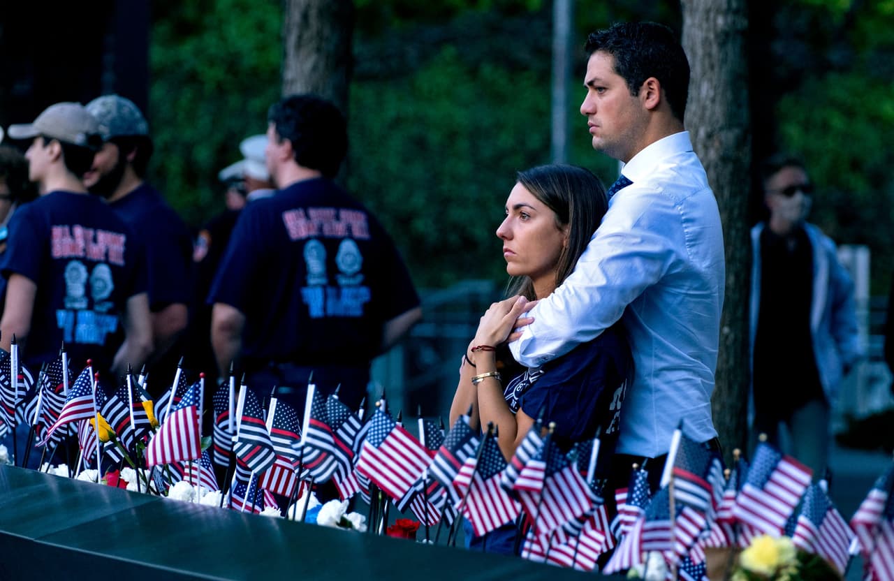 Katie Mascali es consolada por su prometido, Andre Jabban, mientras observa en el monumento el nombre de su padre Joseph Mascali, un teniente de bombero de la compañía de Rescate 5 que murió con el colapso de los edificios.