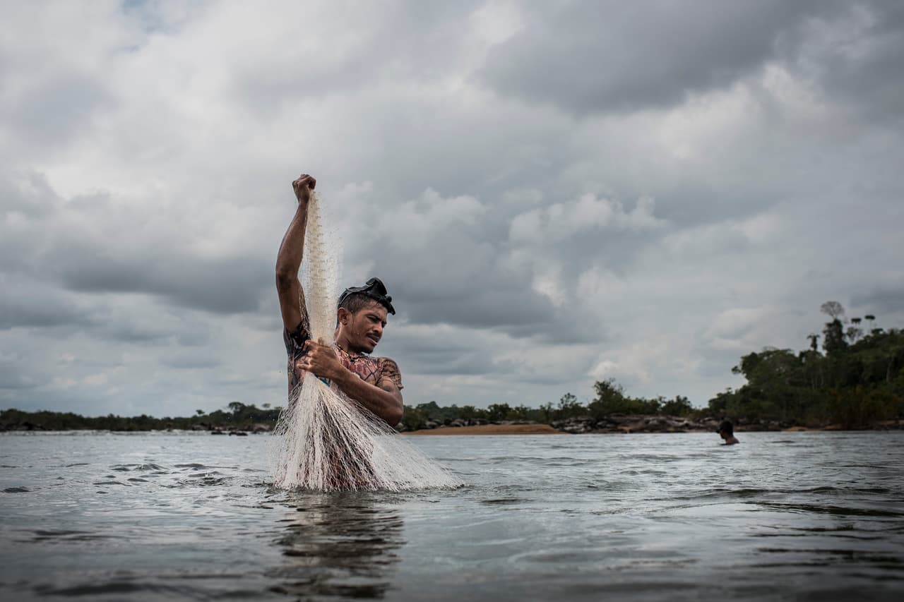 Caboco Juruna from the Juruna village of Miratu fishes for Acarí on the Xingu River. This part of the Xingu River has had it's water flow blocked by the newly completed Belo Monte Dam, severely damaging the fishing livelihoods of the people. The Juruna are now worried that the construction of the Belo Sun gold mine on the Volta Grange will further damage their way of life. Dec 11, 2016