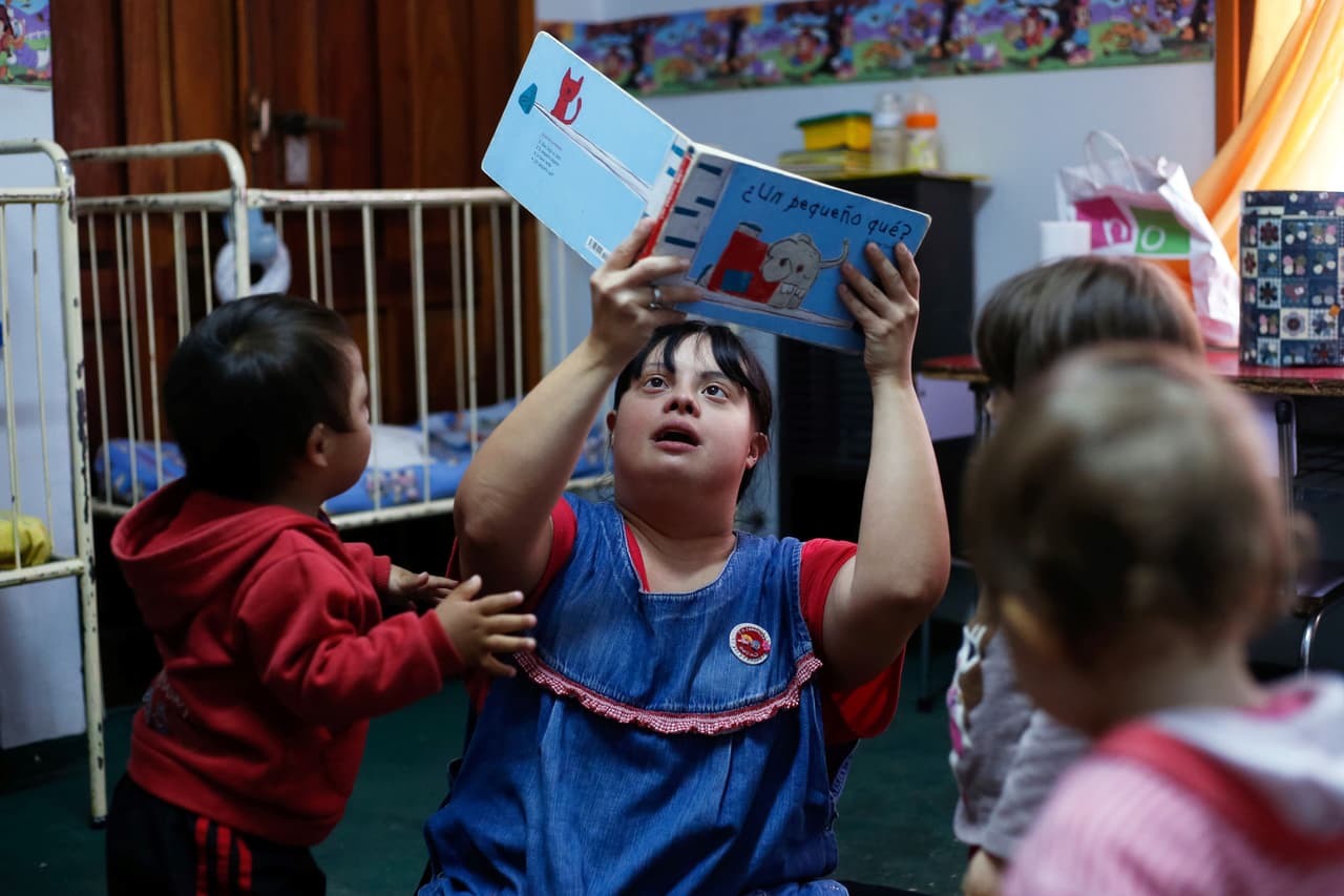 Los niños obedecen a "La Noe" cuando les pide sentarse para contarles un cuento.