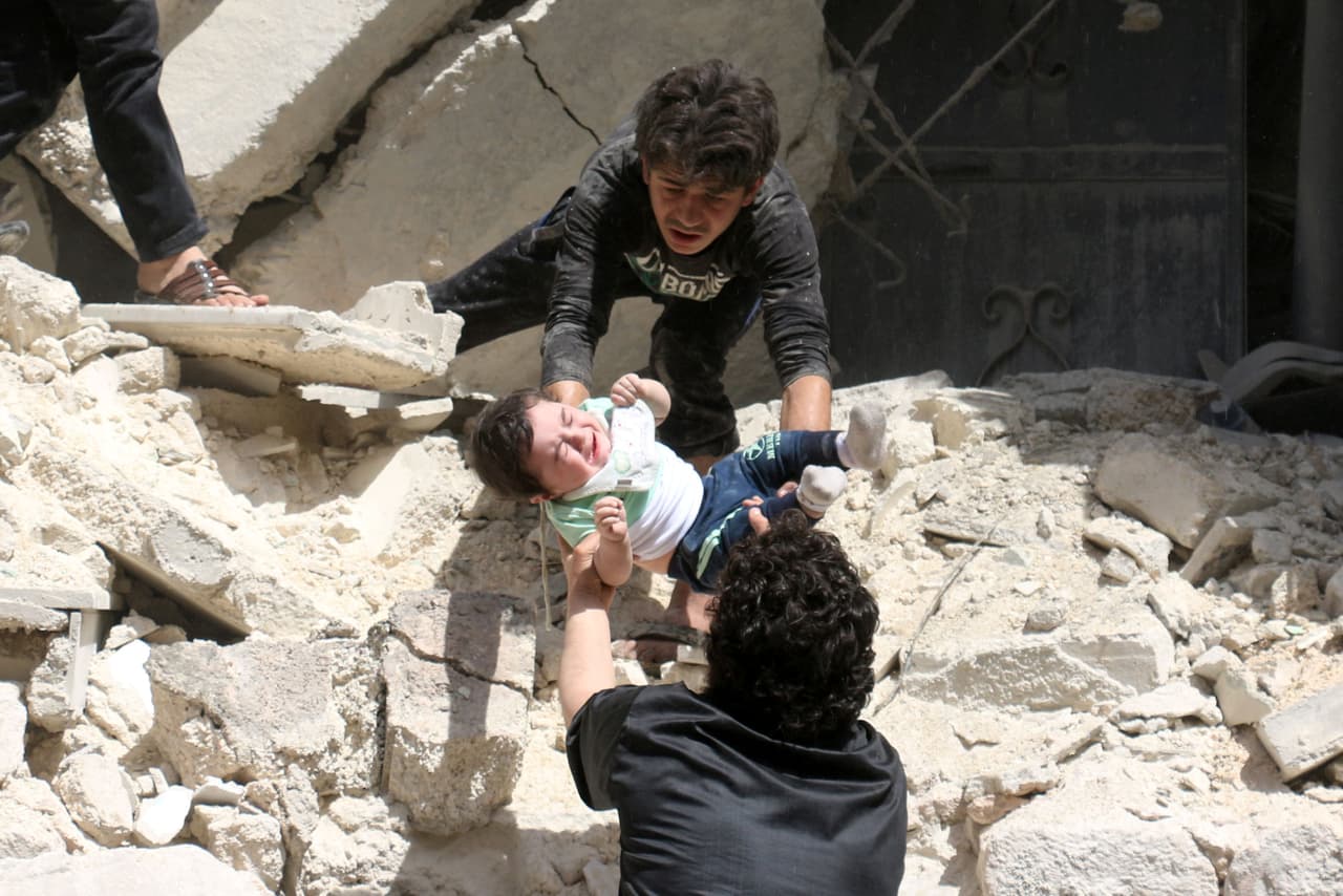 Un grupo de civiles sirios sacan a un niño de los escombros de un edificio bombardeado en la zona de Al-Kalasa, vecindario controlado por los rebeldes en abril de 2016. Sobre los rebeldes, el informe de Amnistía Internacional explica que “el grupo armado Estado Islámico impuso asedios en zonas civiles controladas por el gobierno; efectuó ataques directos contra civiles, así como atentados suicidas con bomba, presuntos ataques con armas químicas y bombardeos de zonas civiles, y perpetró numerosos homicidios, en muchos casos de personas cautivas”.
<br>